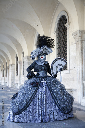 Venice Carnival masks and  comtumes under the arcade of the Doges Palace St. Mark's Square