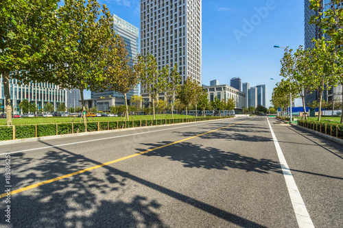 empty road and modern office block buildings against sky, china.