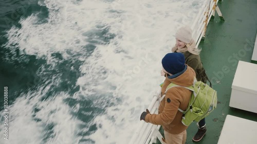 Top view of young couple traveling on the speed boat. Man and woman enjoying the beautiful landscape of the sea.