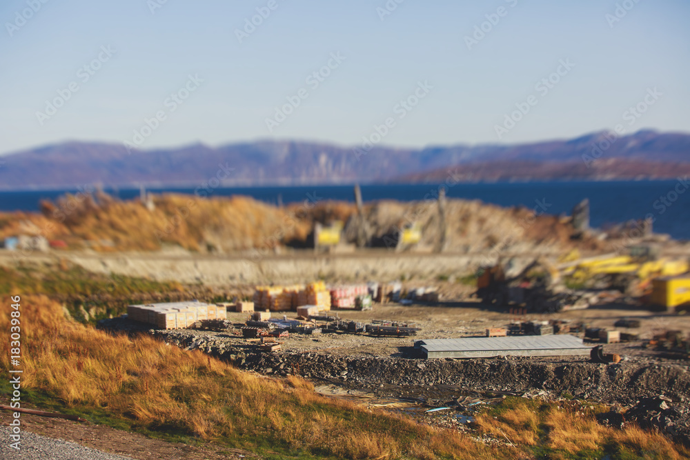 Fototapeta premium Construction site, process of new road construction with heavy vehicle at building work, heavy excavator and bulldozer unloading road metal during road work