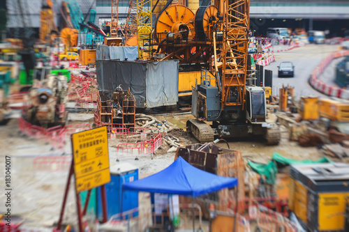 A large construction site in the city, the process of massive buliding construction with heavy vehicle at work, excavator, elevating crane and bulldozer © tsuguliev
