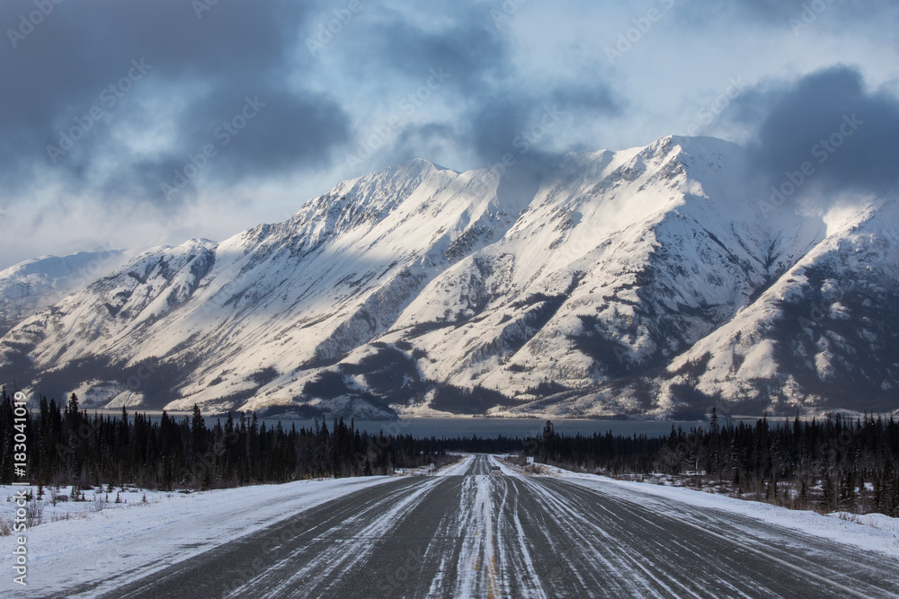 A view down the Alaska Highway towards large mountains