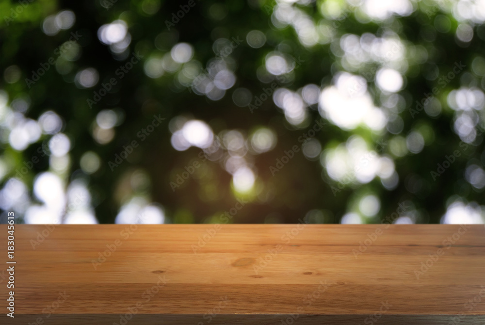 Image of dark wooden table in front of abstract blurred background of outdoor garden lights. can be used for display or montage your products.Mock up for display of product Image of dark wooden table in front of abstract blurred background of outdoor garden lights. can be used for display or montage your products.Mock up for display of product