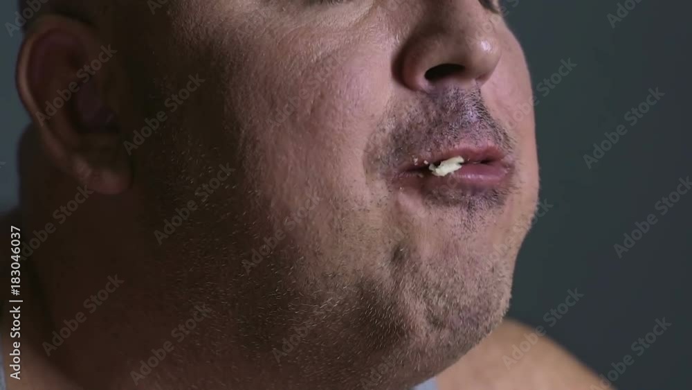 Fat man chewing food delightfully, inability to control junk food consumption Fat man chewing food delightfully, inability to control junk food consumption