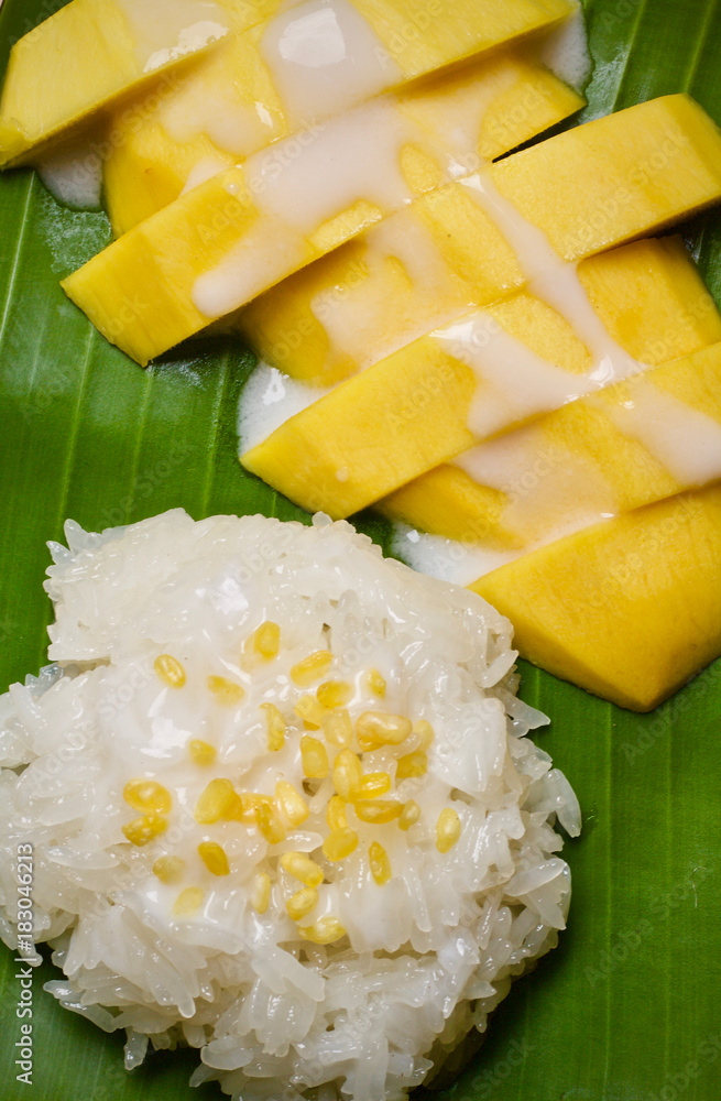 Sticky rice mango ,Thai dessert on banana leaf wooden table Sticky rice mango ,Thai dessert on banana leaf wooden table