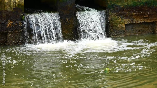 Wallpaper Mural Daily life video After the rain. Water from a canal in the city is dropping down to the sea. To drain water and to prevent flooding in the city in flooding concept. Torontodigital.ca