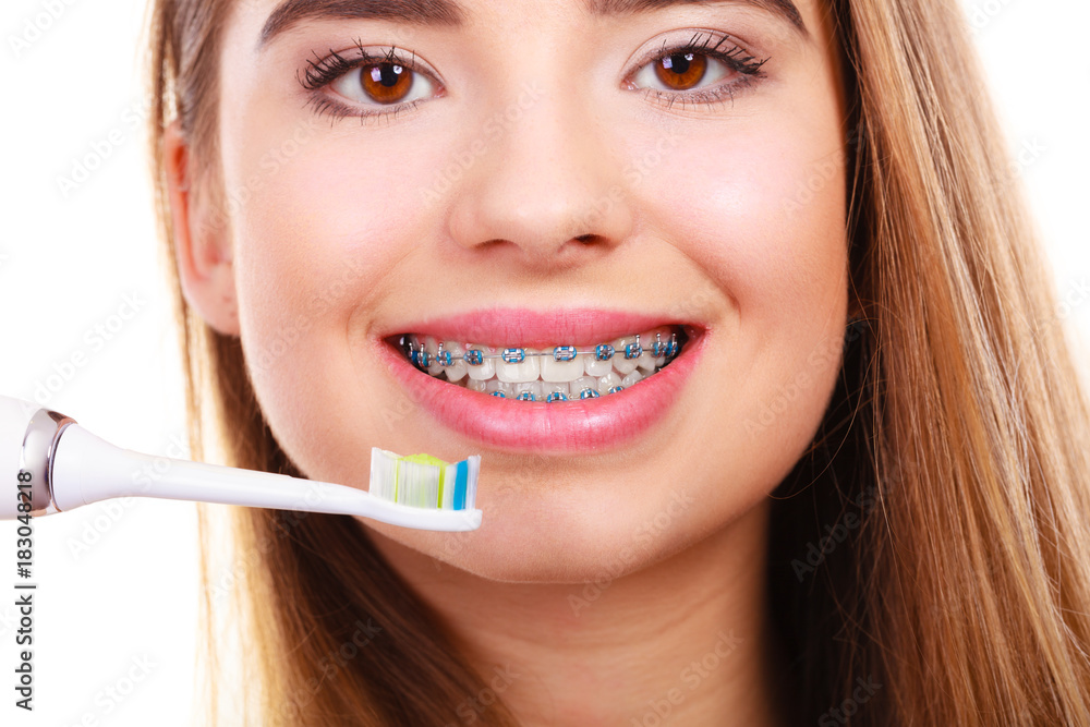 Woman brushing teeth with braces using brush Woman brushing teeth with braces using brush
