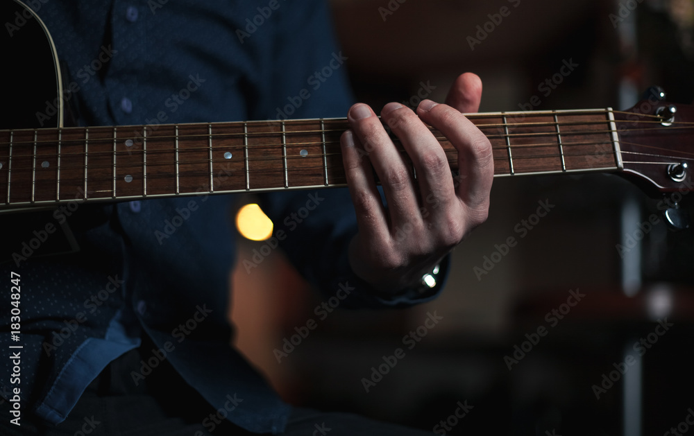 The Guitarist Guy plays the guitar in a bar in a beautiful setting on a high bar stool