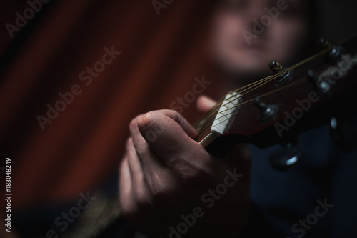 The Guitarist Guy plays the guitar in a bar in a beautiful setting on a high bar stool