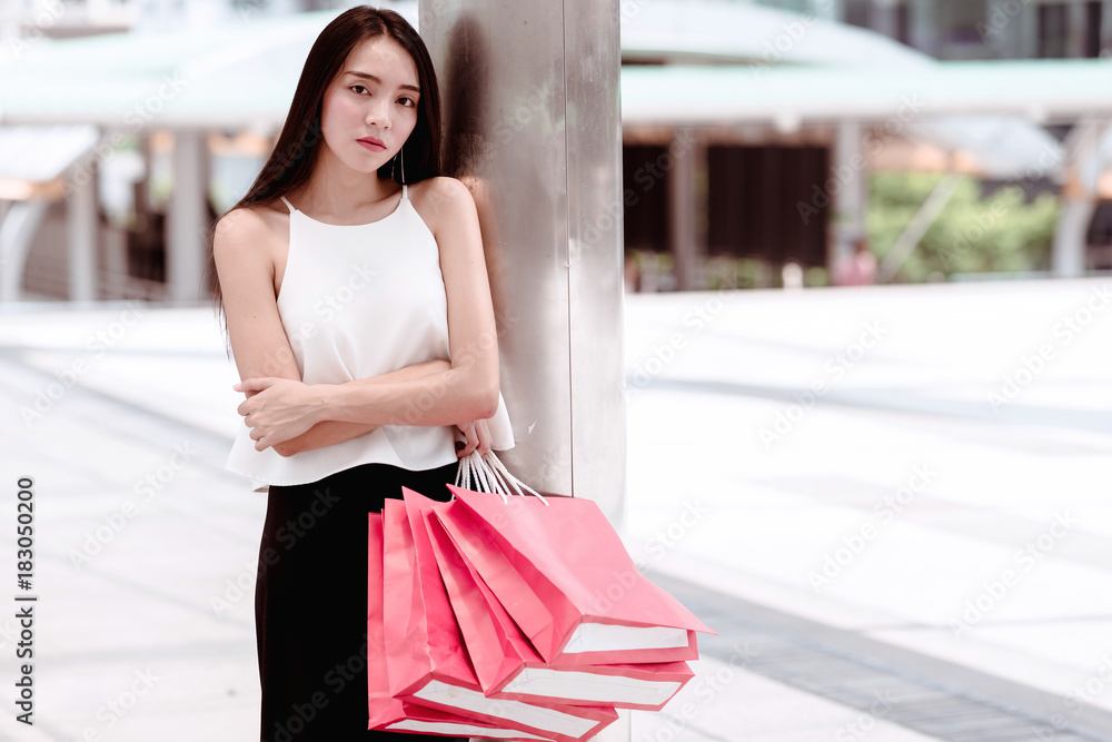 Fototapeta premium Modern shopper waiting for taxi, cab, driver in urban city concept.