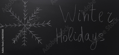 drawn snowflake on blackboard with text: Winter Holidays