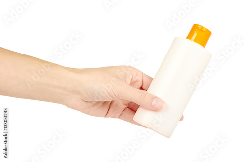 Plastic white shampoo bottle with orange cap in hand isolated on white background. Gel dispenser for hair care. Container with body lotion.