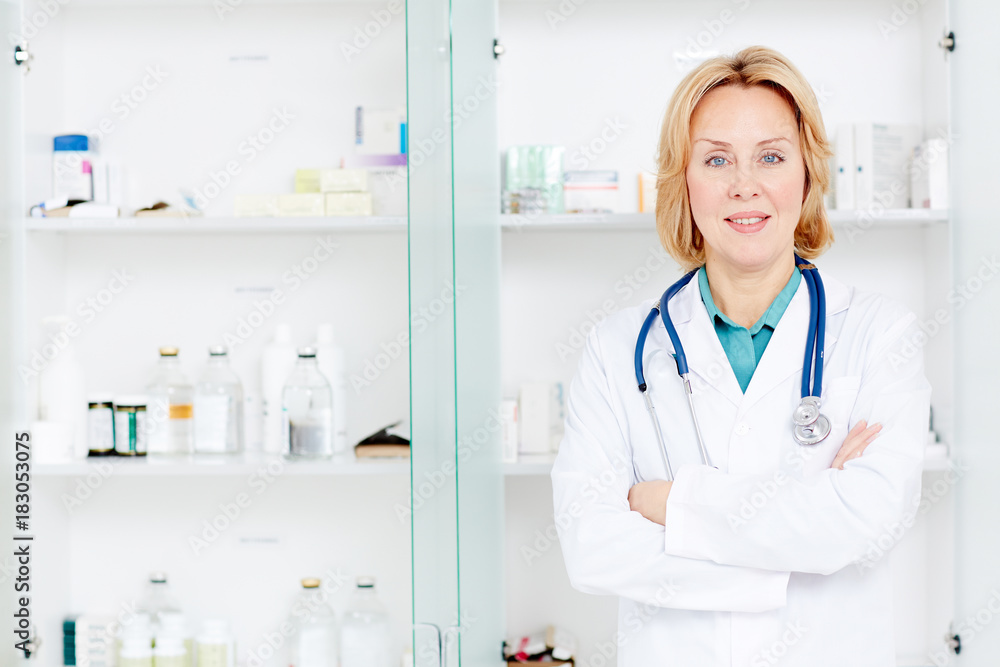 Experienced doctor in whitecoat crossing her arms on chest while looking at camera Experienced doctor in whitecoat crossing her arms on chest while looking at camera