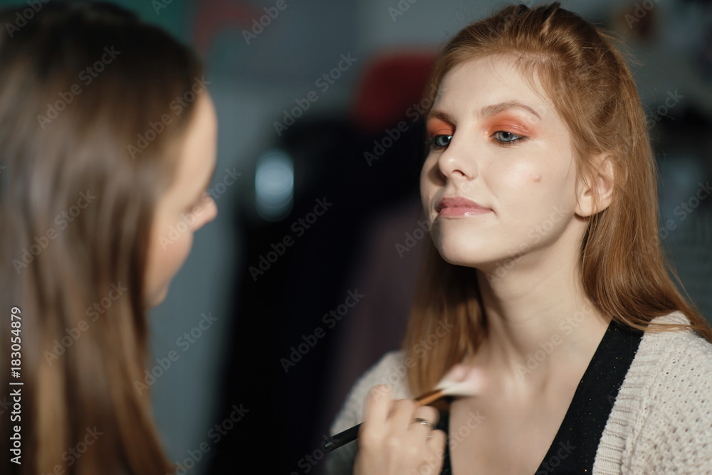 Makeup artist making make-up for a beautiful young woman at home Makeup artist making make-up for a beautiful young woman at home