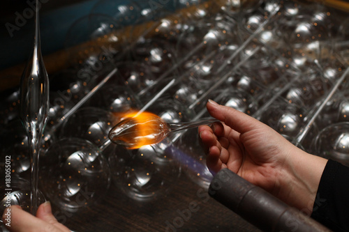 Factory of Christmas toys. The worker blows out the glass. The b