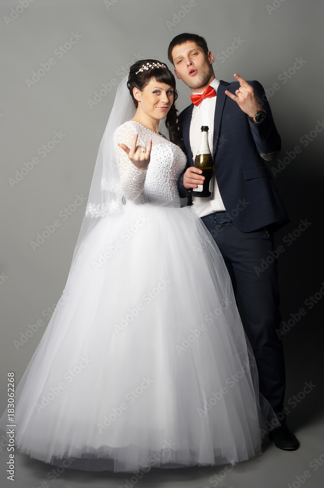 Beautiful young bride and groom posing at studio