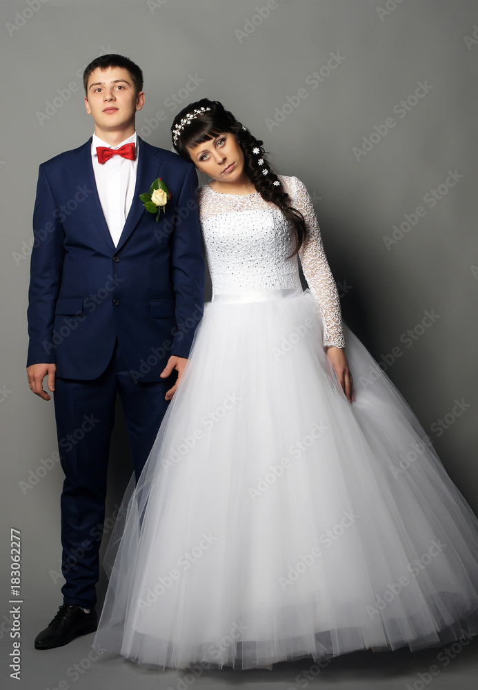 Beautiful young bride and groom posing at studio Beautiful young bride and groom posing at studio