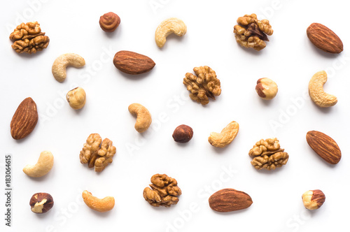 Isolated nuts pattern backdrop. Walnut, cashew, almond and hazelnut on white background. Top view. 