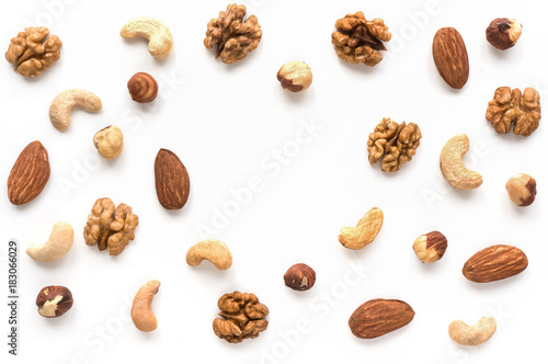 Isolated nuts pattern backdrop with copy space. Walnut, cashew, almond and hazelnut on white background. Top view. 