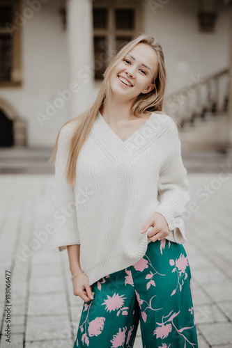 fashionable young woman posing outside in city street