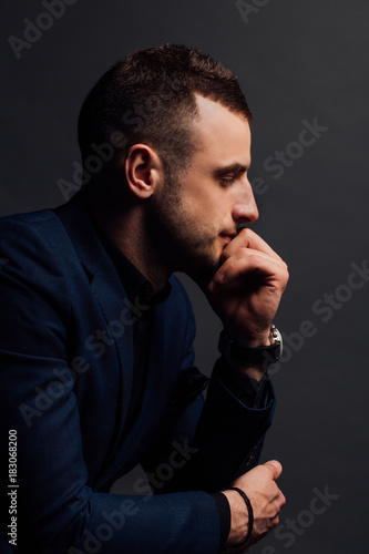 Close-up Studio portrait of young sexy man face hand-touch , holding chin, looking.