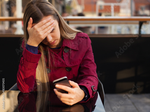 Worried teenager girl looking at her smart phone