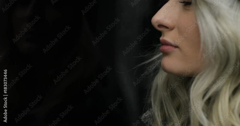 Close-up portrait of beautiful sad girl riding a public transport at night. Woman looking at the camera Close-up portrait of beautiful sad girl riding a public transport at night. Woman looking at the camera