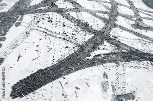 Car tire tracks pattern on dirty wet snow