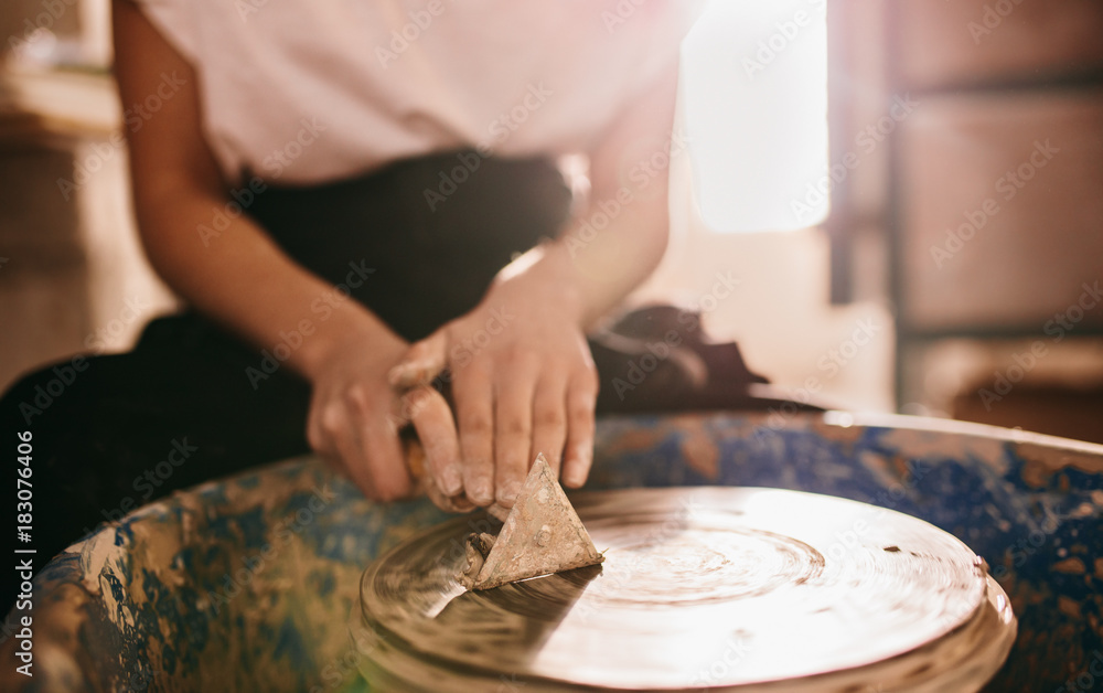 Fototapeta premium Female potter working on potters wheel