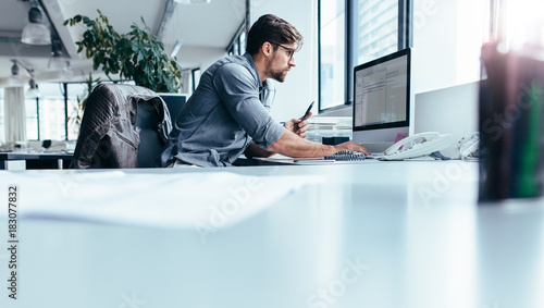 Young businessman in office working on computer