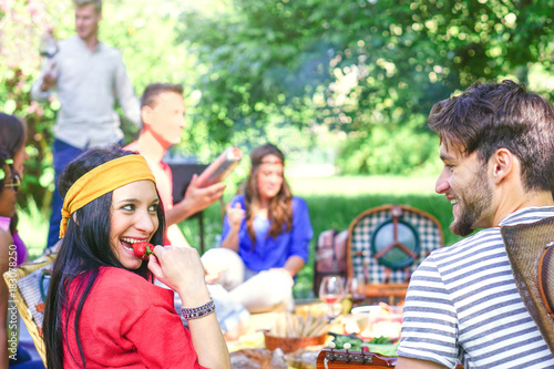 Group of happy friends making a picnic bbq in a park outdoor - Young people having a barbecue party enjoying food and drinks together - Friendship  lifestyle  youth concept - Focus on woman face