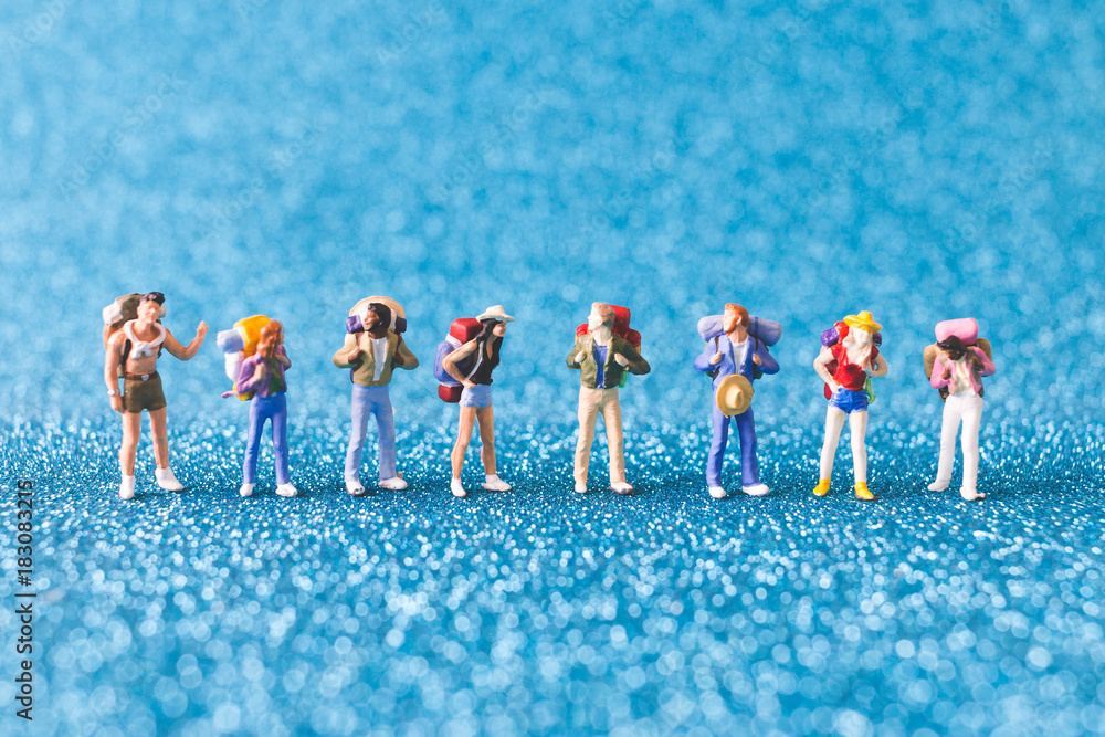 Obraz premium Miniature Backpacker , Tourist people on blue glitter background