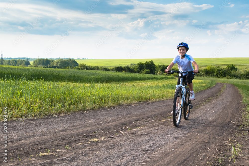 girl on a bicycle in rural landscape