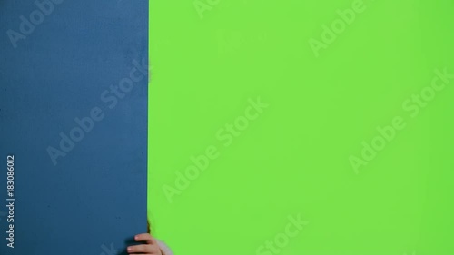 Baby peeking out from behind the blue board. Green screen. Slow motion photo