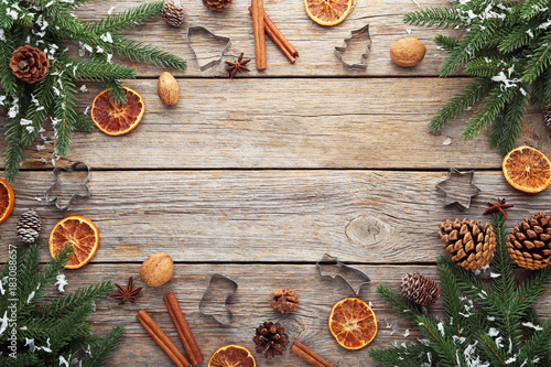 Fir-tree branches with dried orange, walnut and cinnamon on wooden table