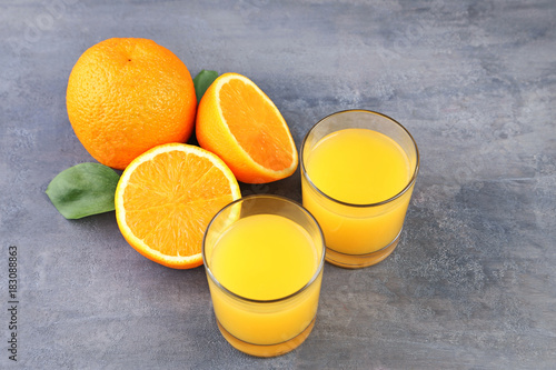Glass of orange juice on grey wooden table