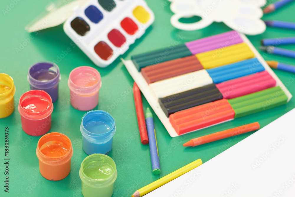 Stationery for creativity. Pencils, paints, an album for drawing lie on a table Stationery for creativity. Pencils, paints, an album for drawing lie on a table
