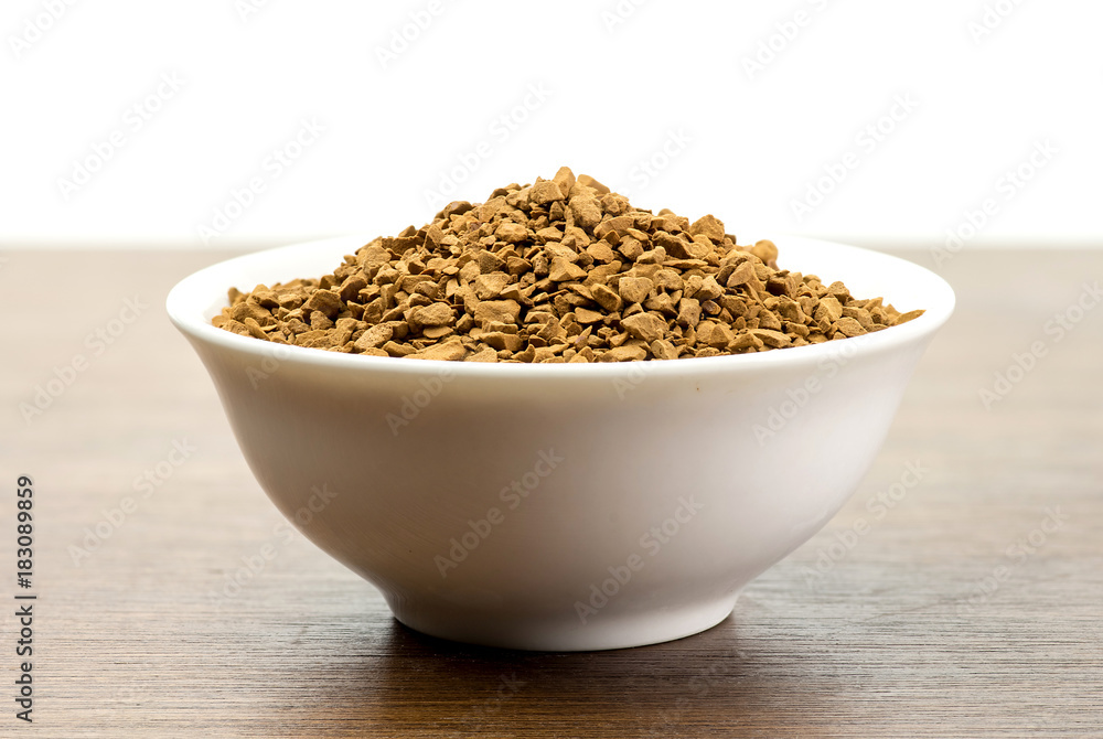 Instant coffee in bowl on wooden table Instant coffee in bowl on wooden table