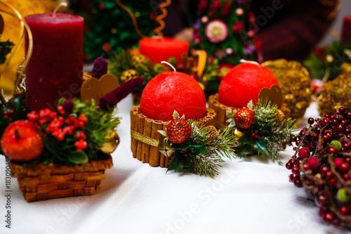 Candle decorated with cinnamon sticks and red apples, christmas decoration