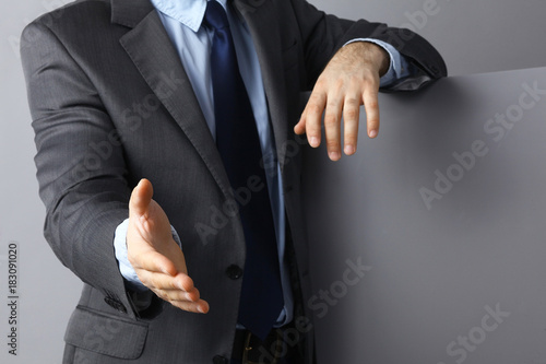 Man wearing a suit offering to shake hands