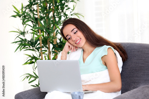 Young woman using laptop wh...
