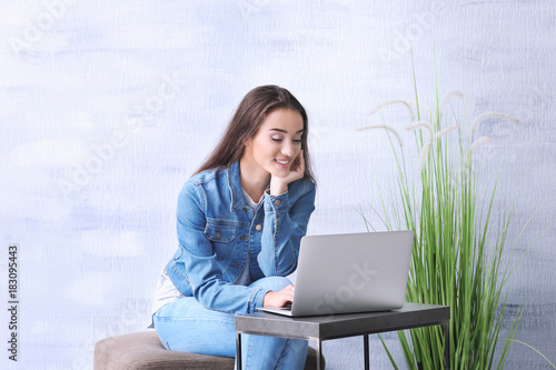Young woman using laptop wh...