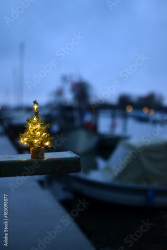 A little christmas tree in a port with ships and boats
