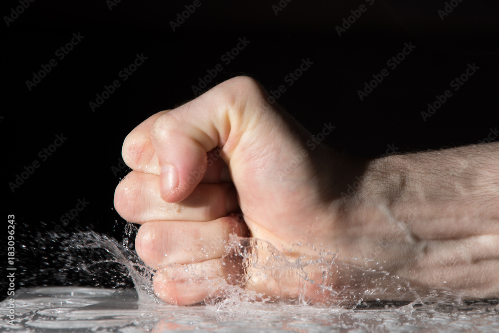 Fototapeta premium Splash of water drops after fist on the table