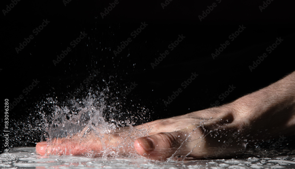 Fototapeta premium Splash of water drops after clap hand on the table