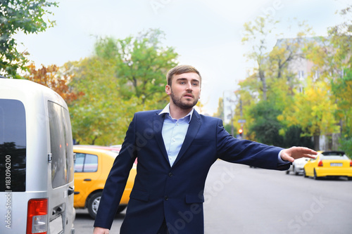 Wallpaper Mural Young businessman catching taxi on city street Torontodigital.ca