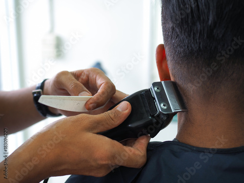 Fotografija man getting haircut at barber shop