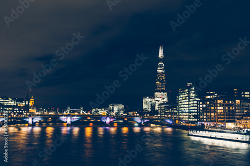 Long exposure shot at night on River Thames with shard building on cityscape skyline
