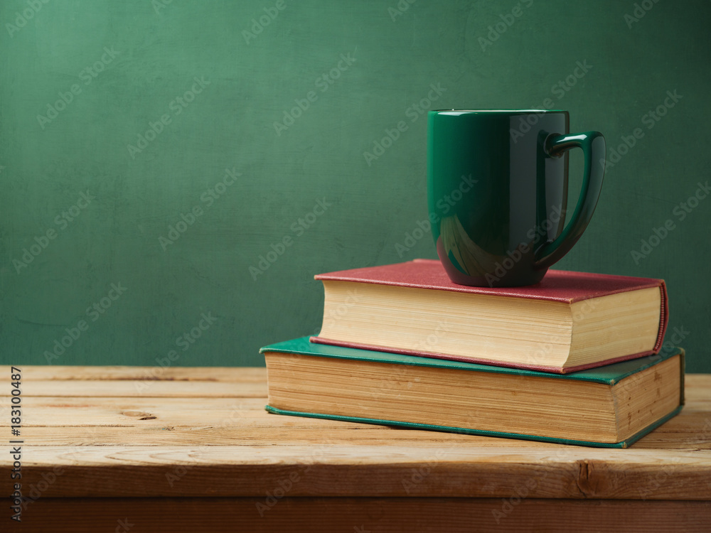 Green cup of coffee on stack of books Green cup of coffee on stack of books