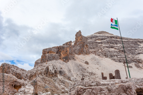 Italian flag waving at the foot of the Tofana di Rozes Peak, Fontananegra Pass, Tofane, Dolomites, Italy